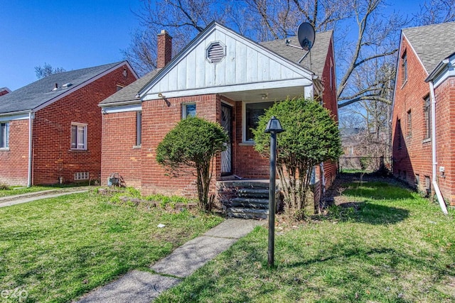 bungalow-style house with board and batten siding, a front yard, brick siding, and a shingled roof