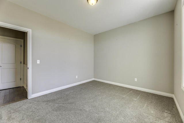 carpeted empty room featuring baseboards