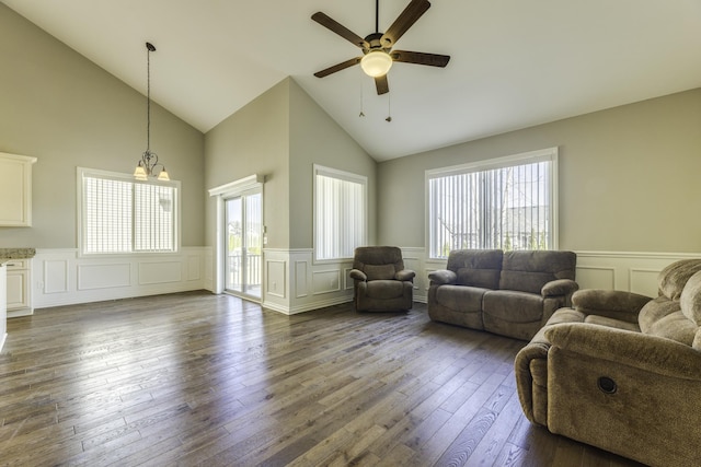 living area featuring ceiling fan, lofted ceiling, dark wood finished floors, and wainscoting