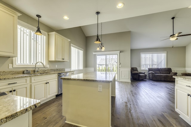 kitchen featuring dark wood-type flooring, dishwasher, vaulted ceiling, wainscoting, and a sink