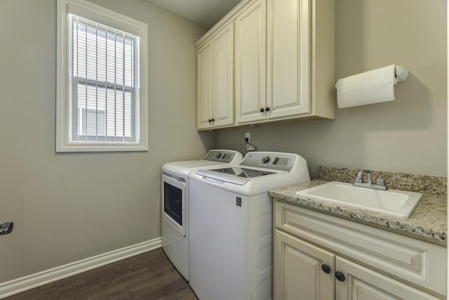 clothes washing area with a sink, washer and dryer, dark wood-style floors, cabinet space, and baseboards