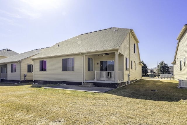 back of house with cooling unit, a yard, ceiling fan, and a shingled roof