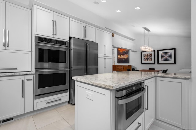 kitchen featuring visible vents, light stone countertops, lofted ceiling, stainless steel appliances, and white cabinetry