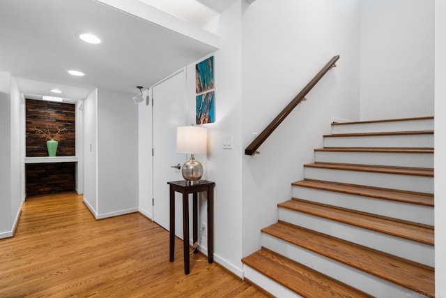 stairs with recessed lighting, baseboards, and wood finished floors