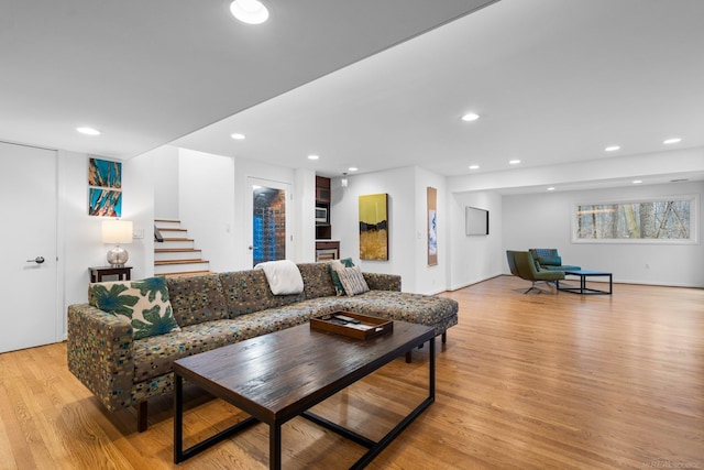 living area featuring recessed lighting, stairway, and light wood-style flooring