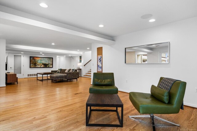 living area featuring light wood-type flooring, visible vents, recessed lighting, stairway, and baseboards