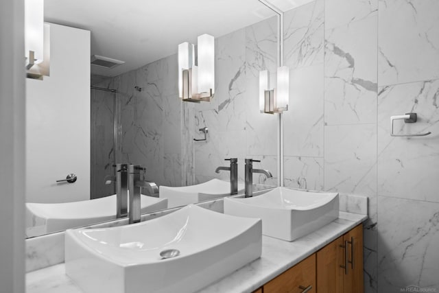 full bath with double vanity, stone wall, and a sink