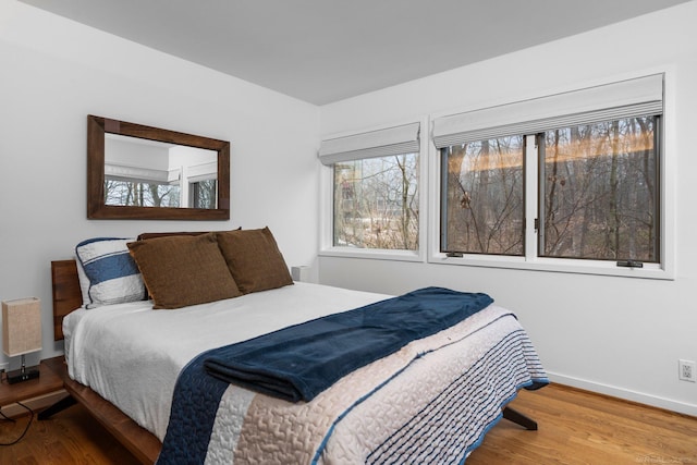 bedroom featuring wood finished floors and baseboards