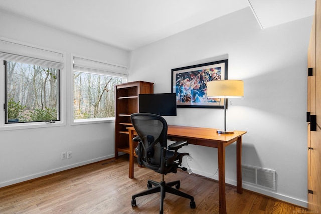 office area featuring visible vents, baseboards, and wood finished floors