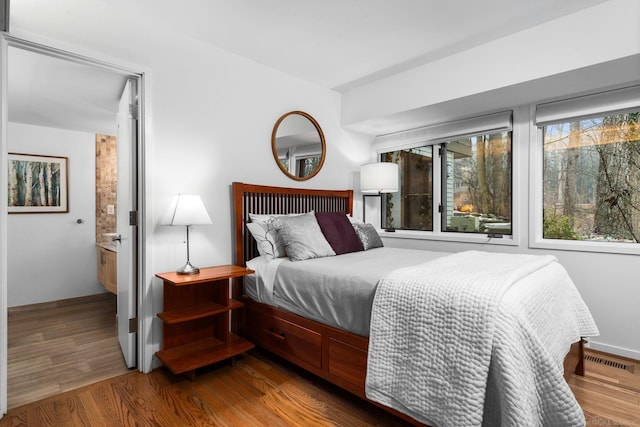 bedroom featuring visible vents and wood finished floors