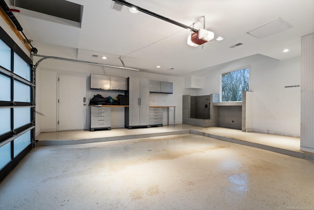 garage featuring recessed lighting, a garage door opener, and visible vents