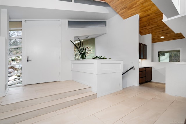 entryway with light tile patterned flooring, a healthy amount of sunlight, and wooden ceiling