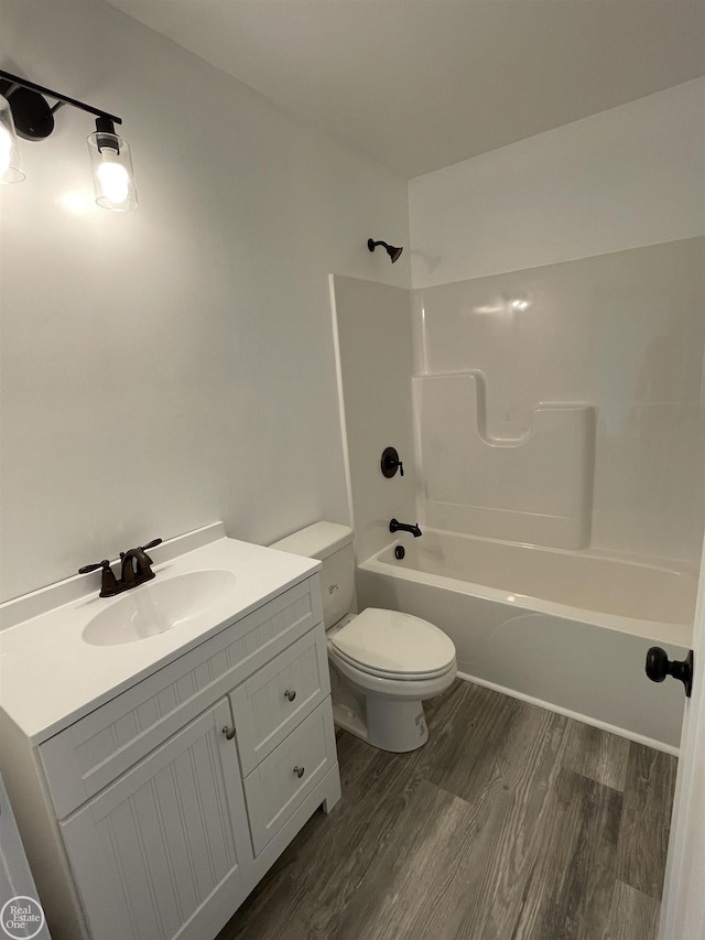 bathroom featuring shower / bathing tub combination, toilet, wood finished floors, and vanity