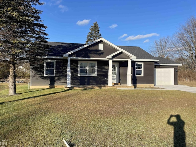 view of front of home with an attached garage, concrete driveway, a front lawn, and a shingled roof