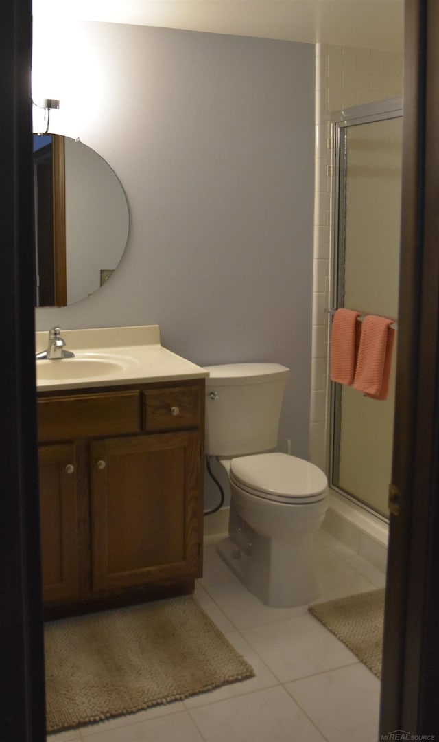 full bathroom featuring vanity, toilet, a shower stall, and tile patterned flooring