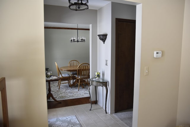 hall featuring light tile patterned floors and a chandelier