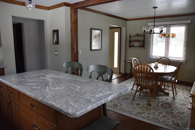 dining room featuring dark wood-type flooring, a notable chandelier, and crown molding