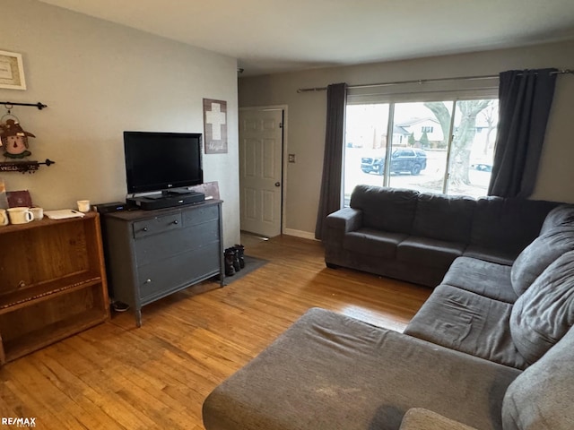 living room with light wood-style flooring and baseboards