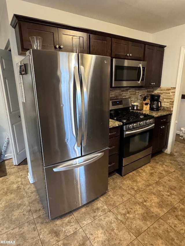 kitchen with dark brown cabinetry, light stone countertops, and appliances with stainless steel finishes