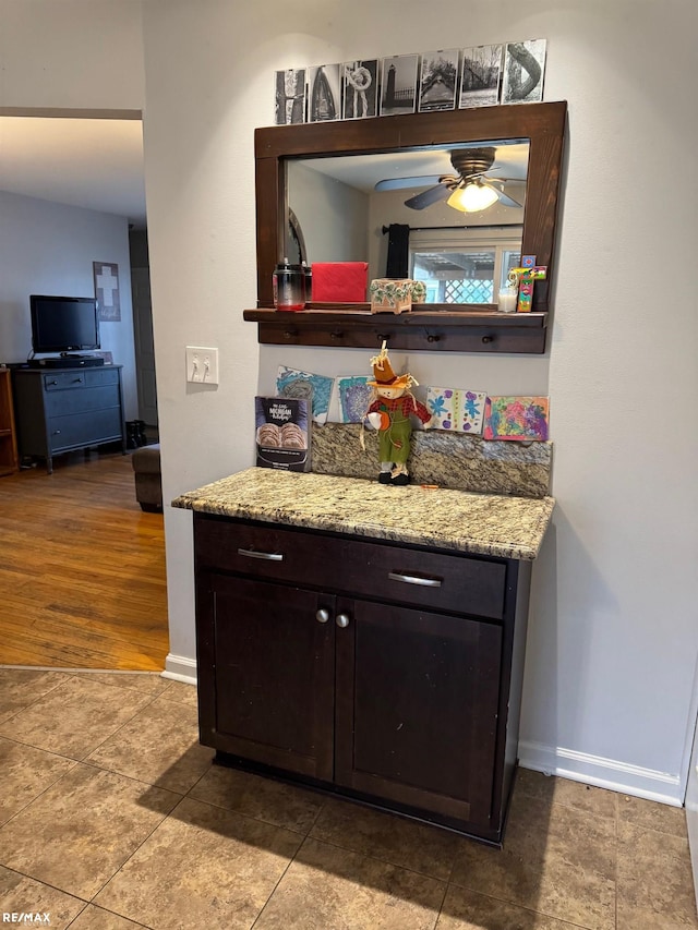 bar with baseboards and ceiling fan