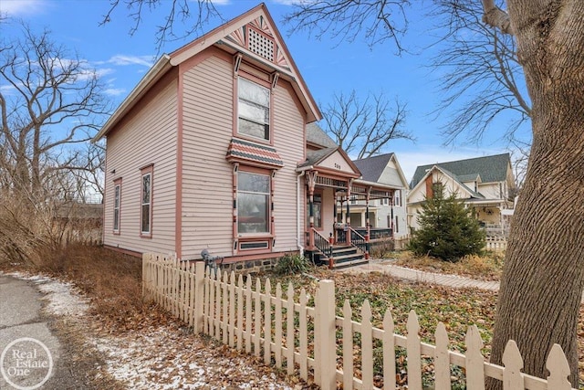 victorian house featuring a fenced front yard