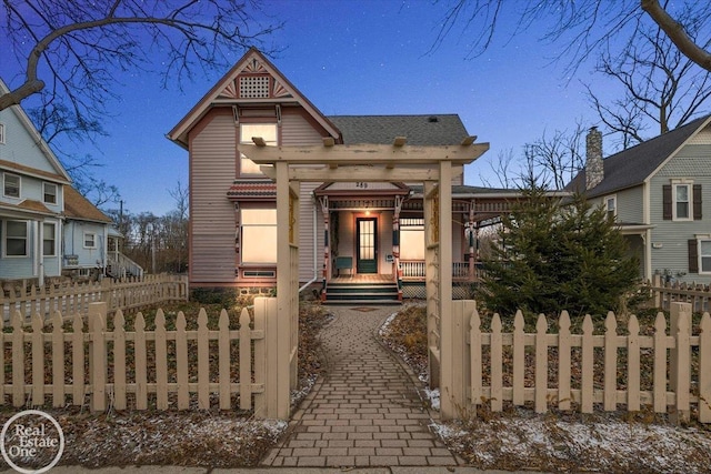 victorian house with a fenced front yard and a porch