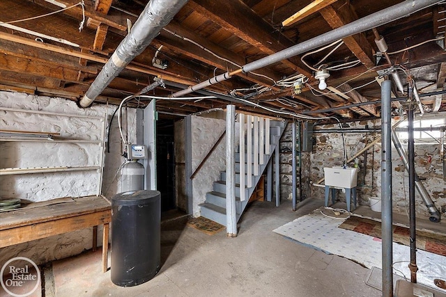 unfinished basement featuring stairway and a sink