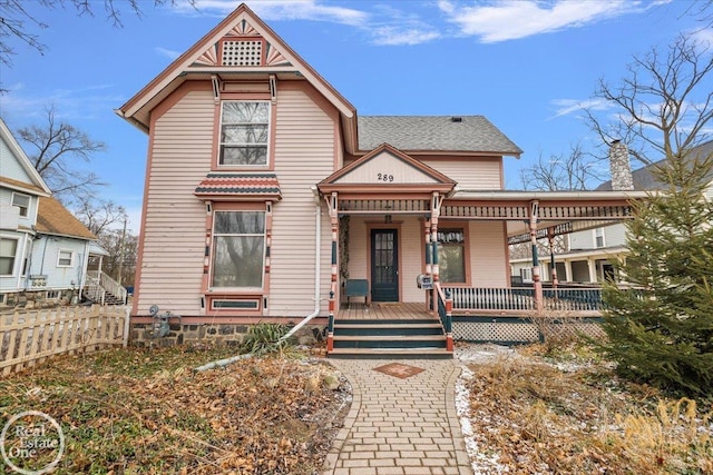 victorian house with fence and covered porch