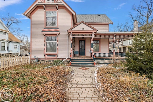 victorian home with a porch and fence