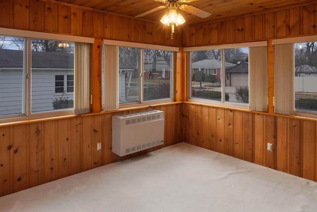 unfurnished sunroom featuring wooden ceiling, heating unit, radiator heating unit, and ceiling fan