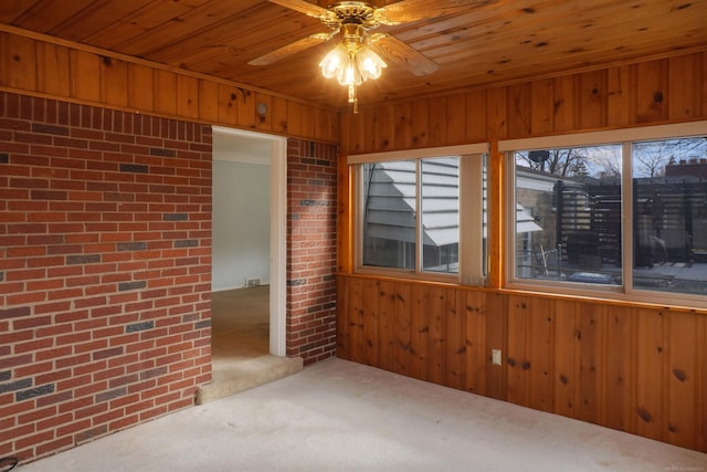 unfurnished room with wooden walls, brick wall, and carpet floors