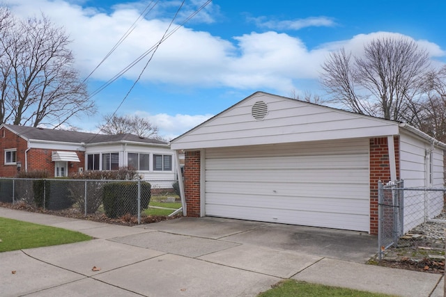 view of front of home with a garage, brick siding, and a fenced front yard