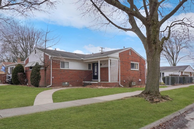 bungalow with brick siding, a front yard, and fence