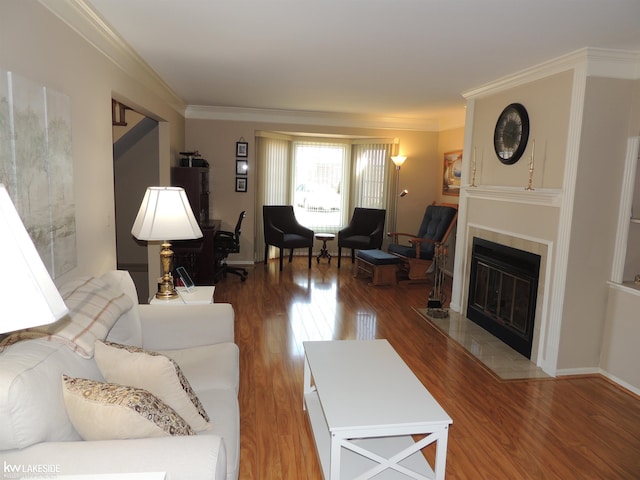 living room featuring crown molding, wood finished floors, and a tile fireplace