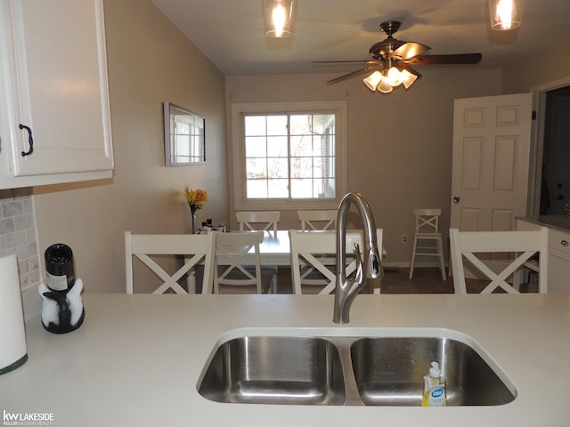 kitchen featuring white cabinetry, light countertops, ceiling fan, and a sink