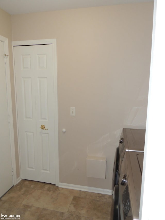 clothes washing area featuring washing machine and clothes dryer and baseboards