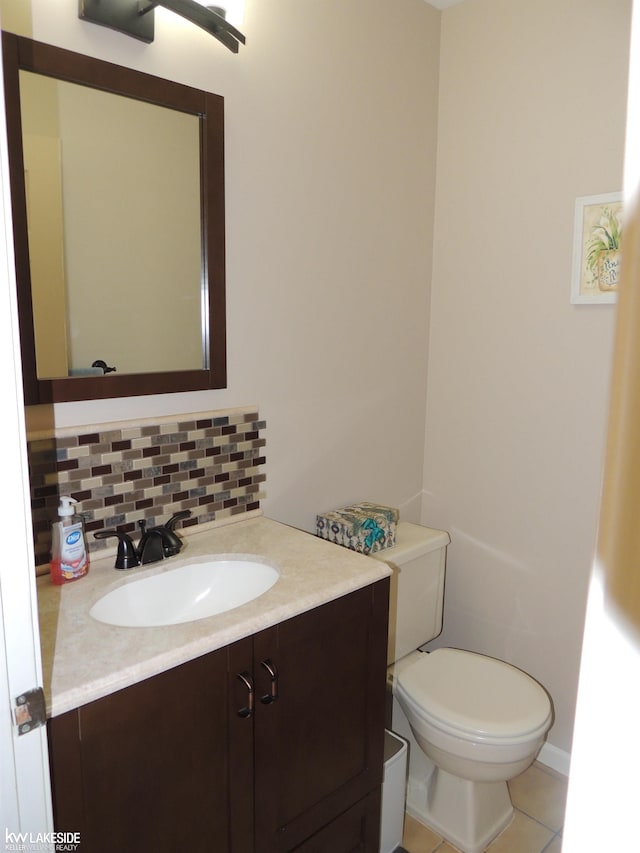 bathroom featuring tile patterned flooring, backsplash, vanity, and toilet