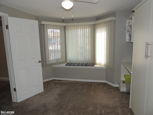 unfurnished dining area featuring baseboards, a ceiling fan, and carpet flooring