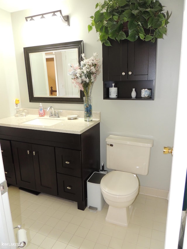 bathroom featuring vanity, tile patterned floors, and toilet