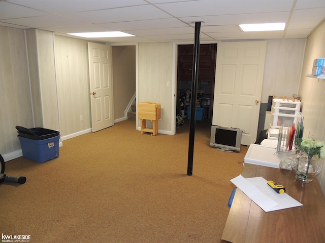 finished basement featuring stairway, a drop ceiling, baseboards, and carpet floors