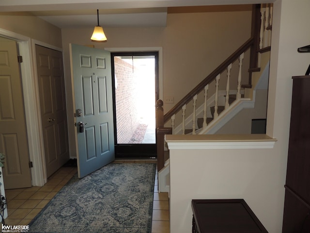 foyer featuring stairway and light tile patterned floors