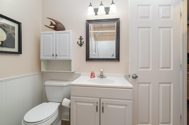 bathroom with wainscoting, vanity, and toilet