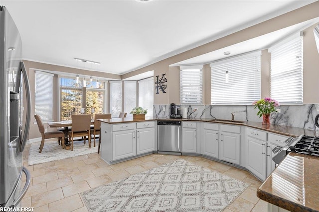 kitchen featuring a sink, a wealth of natural light, appliances with stainless steel finishes, and a peninsula