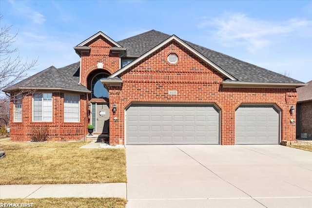 view of front of property featuring a front lawn, brick siding, a garage, and driveway