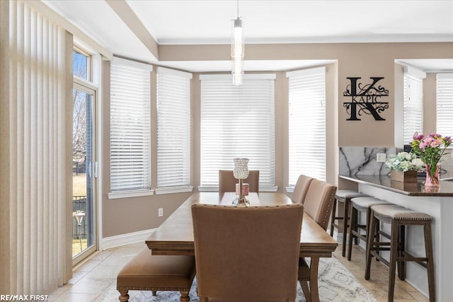 dining room featuring light tile patterned flooring, baseboards, and a wealth of natural light