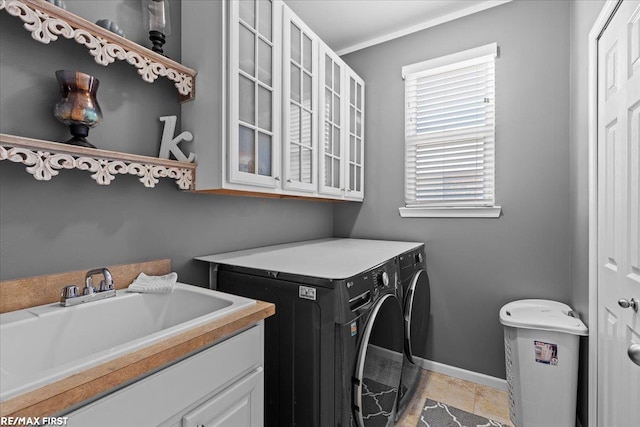 clothes washing area featuring baseboards, cabinet space, ornamental molding, a sink, and washer and dryer