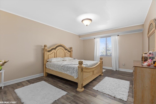 bedroom with crown molding, wood finished floors, and baseboards