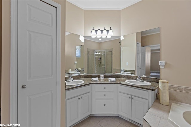 bathroom with double vanity, a stall shower, tile patterned floors, and a sink