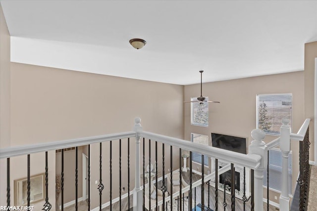 corridor featuring baseboards and an upstairs landing