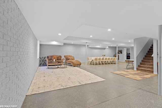 interior space featuring recessed lighting, stairway, speckled floor, and brick wall